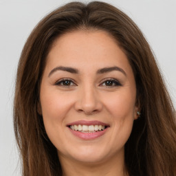 Joyful white young-adult female with long  brown hair and brown eyes