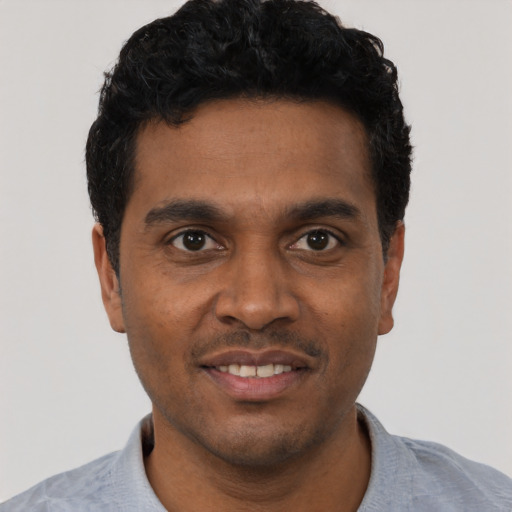 Joyful black young-adult male with short  black hair and brown eyes