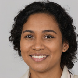 Joyful latino adult female with medium  brown hair and brown eyes