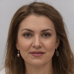 Joyful white adult female with long  brown hair and grey eyes