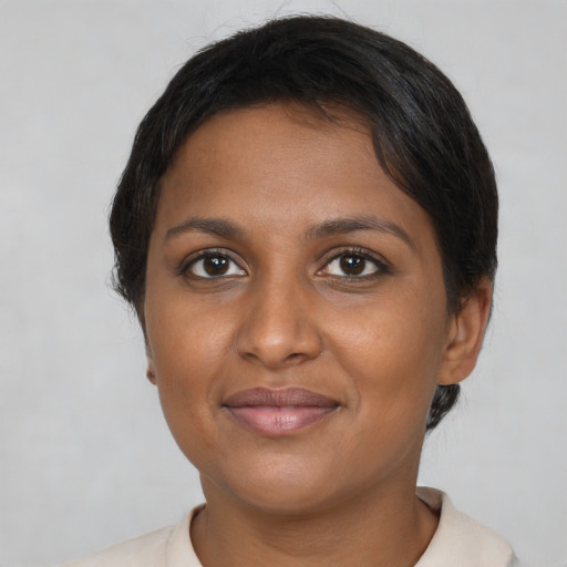 Joyful black adult female with short  brown hair and brown eyes