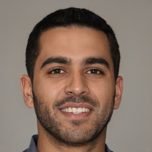 Joyful latino young-adult male with short  black hair and brown eyes