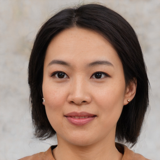 Joyful asian young-adult female with medium  brown hair and brown eyes