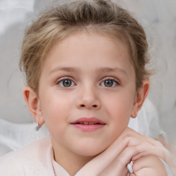 Joyful white child female with short  brown hair and blue eyes