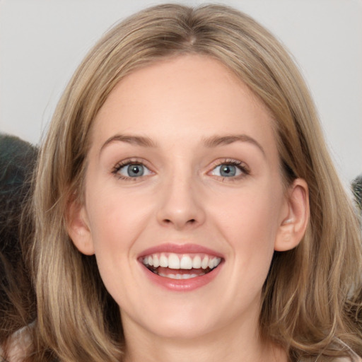 Joyful white young-adult female with long  brown hair and grey eyes