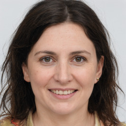 Joyful white adult female with long  brown hair and grey eyes