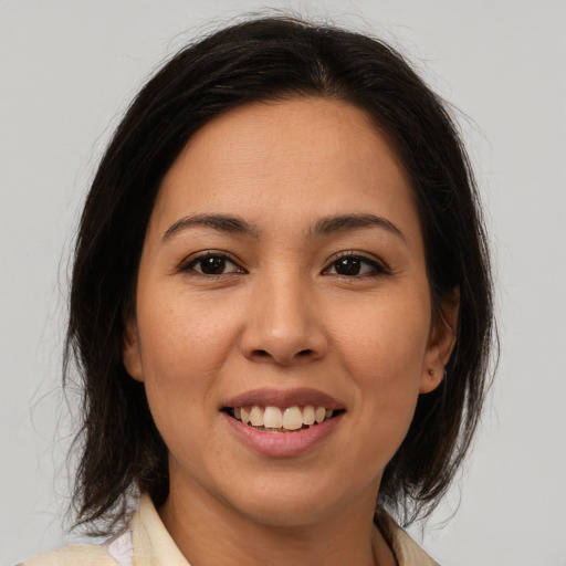 Joyful latino young-adult female with medium  brown hair and brown eyes