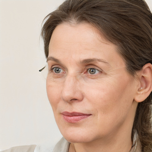 Joyful white adult female with medium  brown hair and grey eyes