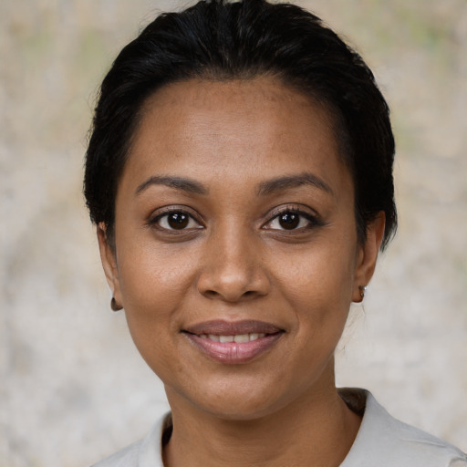 Joyful latino young-adult female with short  black hair and brown eyes