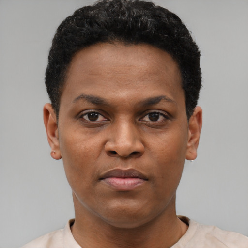 Joyful black young-adult male with short  black hair and brown eyes