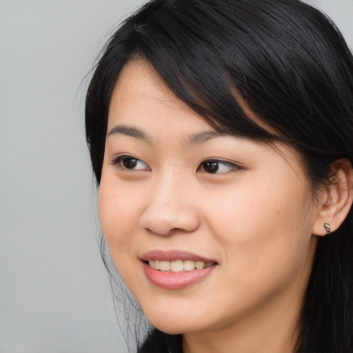 Joyful asian young-adult female with long  black hair and brown eyes