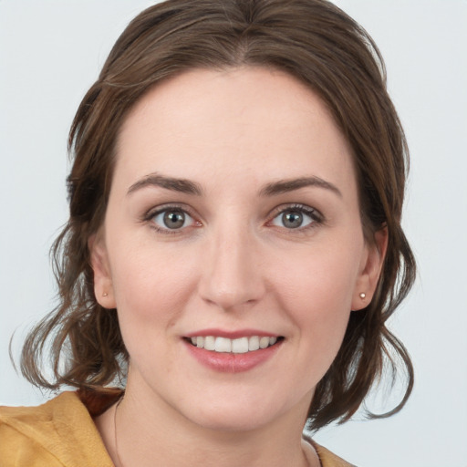 Joyful white young-adult female with medium  brown hair and blue eyes