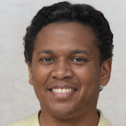 Joyful latino young-adult male with short  brown hair and brown eyes