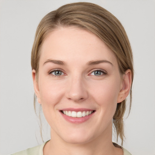 Joyful white young-adult female with medium  brown hair and grey eyes