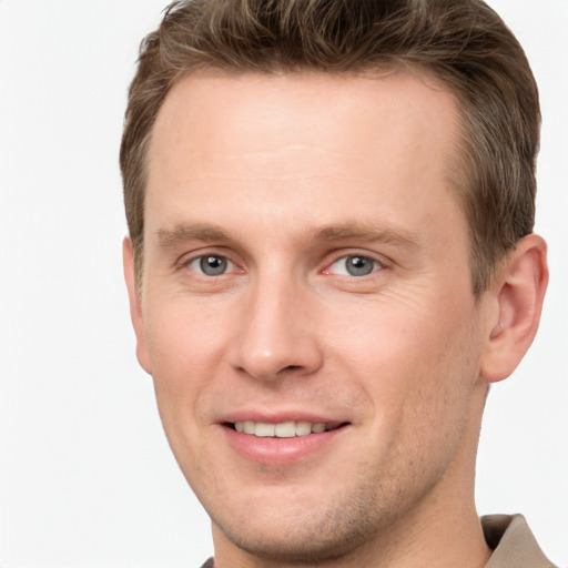 Joyful white young-adult male with short  brown hair and grey eyes