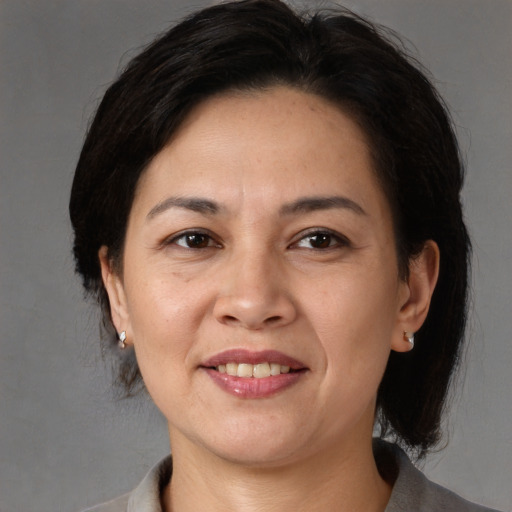 Joyful asian adult female with medium  brown hair and brown eyes