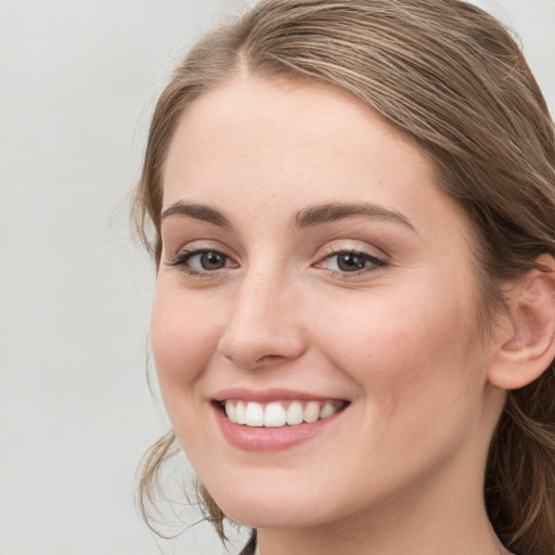 Joyful white young-adult female with long  brown hair and grey eyes