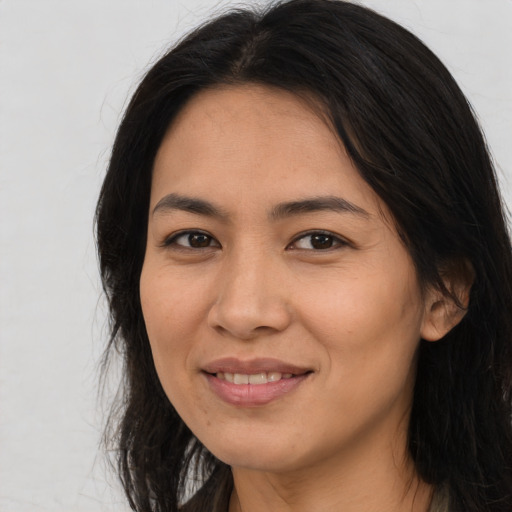 Joyful asian young-adult female with long  brown hair and brown eyes