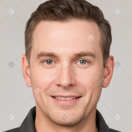 Joyful white young-adult male with short  brown hair and grey eyes