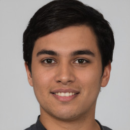 Joyful white young-adult male with short  black hair and brown eyes