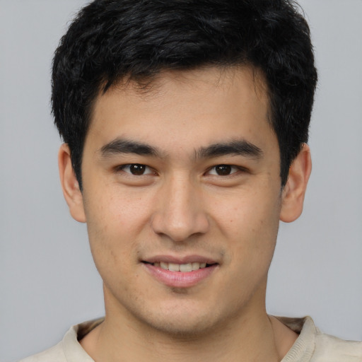 Joyful asian young-adult male with short  brown hair and brown eyes