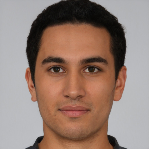 Joyful latino young-adult male with short  brown hair and brown eyes