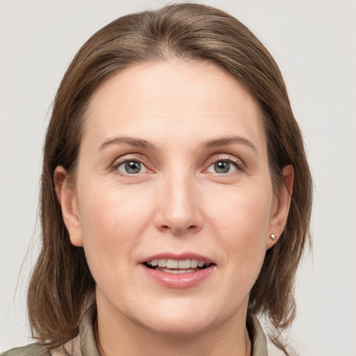 Joyful white young-adult female with medium  brown hair and grey eyes