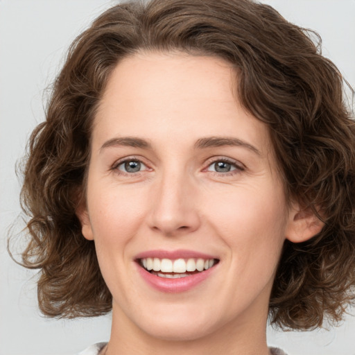 Joyful white young-adult female with medium  brown hair and green eyes