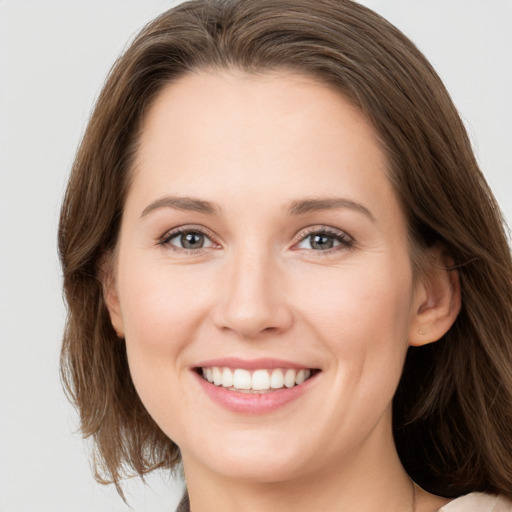 Joyful white young-adult female with medium  brown hair and grey eyes