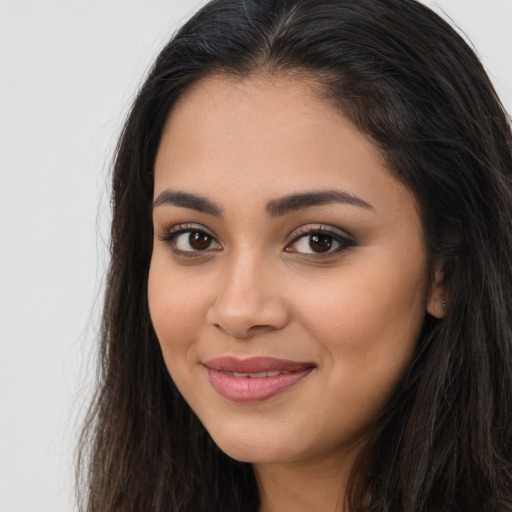 Joyful latino young-adult female with long  brown hair and brown eyes