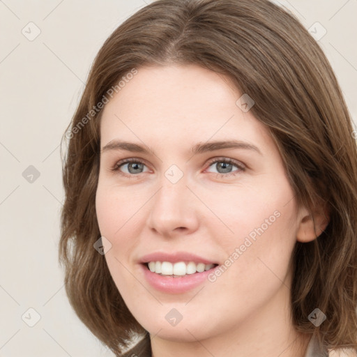 Joyful white young-adult female with medium  brown hair and green eyes