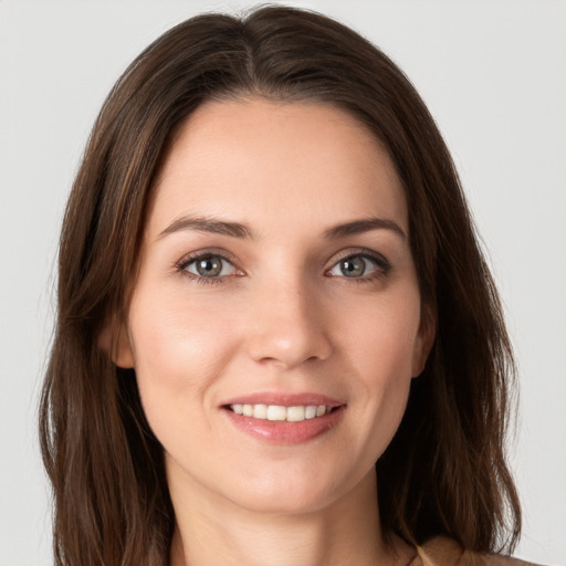 Joyful white young-adult female with long  brown hair and grey eyes