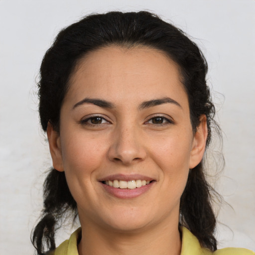 Joyful latino adult female with medium  brown hair and brown eyes