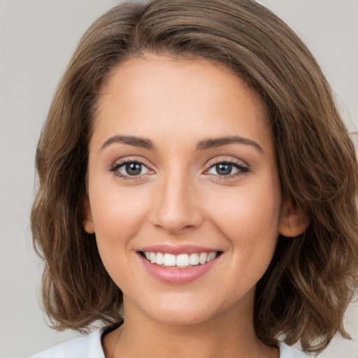 Joyful white young-adult female with long  brown hair and green eyes