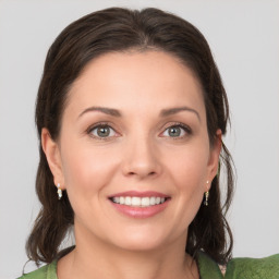 Joyful white young-adult female with medium  brown hair and grey eyes