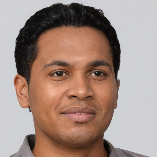 Joyful latino young-adult male with short  black hair and brown eyes