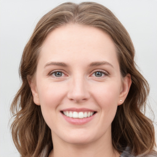 Joyful white young-adult female with medium  brown hair and grey eyes