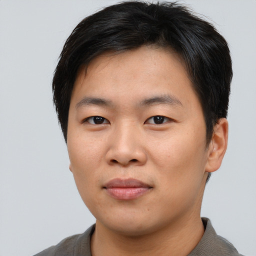 Joyful asian young-adult male with short  brown hair and brown eyes