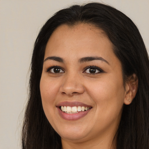 Joyful latino young-adult female with long  brown hair and brown eyes