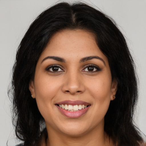 Joyful latino young-adult female with long  brown hair and brown eyes
