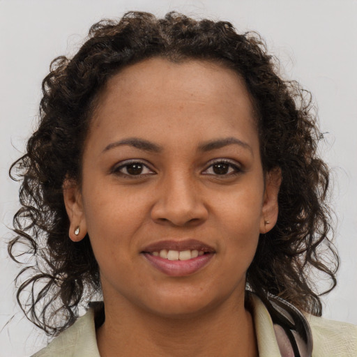 Joyful black young-adult female with long  brown hair and brown eyes