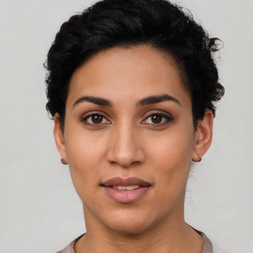 Joyful latino young-adult female with short  black hair and brown eyes