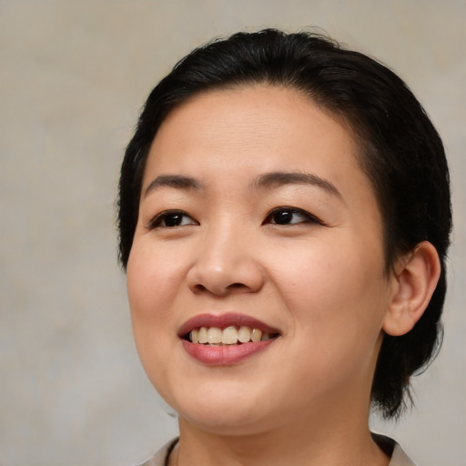Joyful asian young-adult female with medium  brown hair and brown eyes