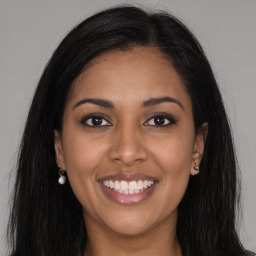 Joyful black young-adult female with long  brown hair and brown eyes