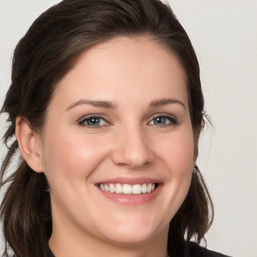 Joyful white young-adult female with medium  brown hair and grey eyes