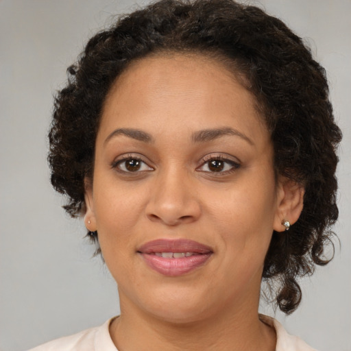 Joyful black adult female with medium  brown hair and brown eyes