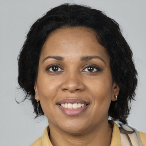 Joyful black adult female with long  black hair and brown eyes