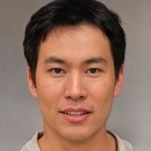 Joyful asian young-adult male with short  brown hair and brown eyes