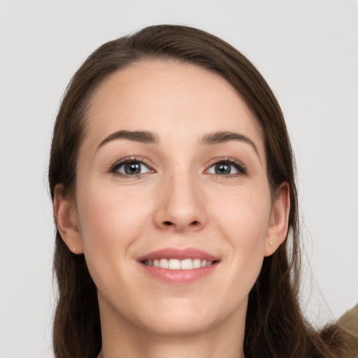 Joyful white young-adult female with long  brown hair and grey eyes