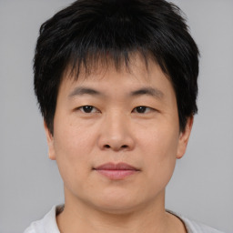 Joyful asian young-adult male with short  brown hair and brown eyes